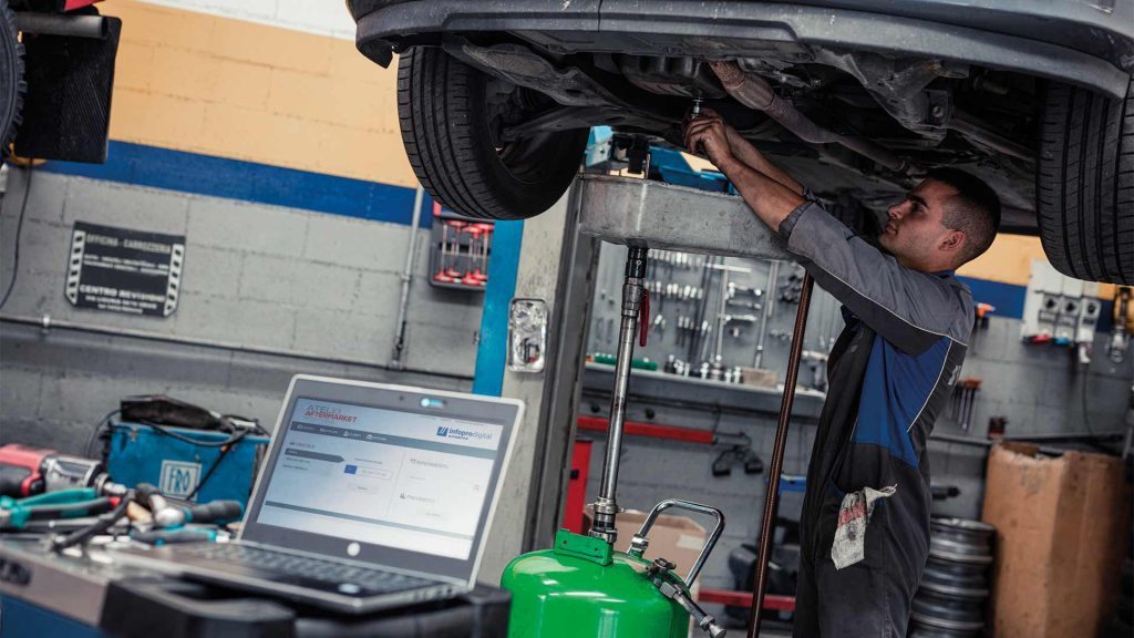 Un uomo in un'officina utilizza l'aiuto di Atelio Aftermarket sul suo computer