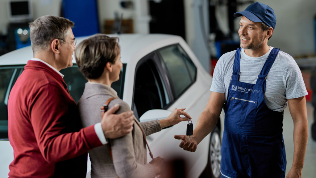 Uk Mechanic with customers in the workshop using Atelio Fid to improve business performance
