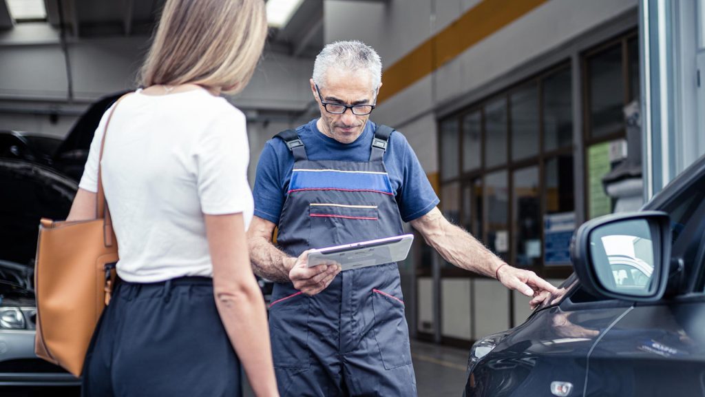 Meccanico con cliente utilizza il software gestionale per officine atelio pro sul suo tablet