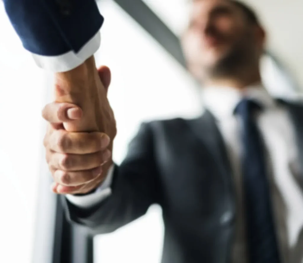 Un expert d'Infopro Digital Automotive et un client se serrent la main après une consultation gratuite.