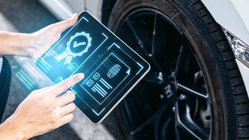 Person using a digital tablet to analyze tire and wheel data for vehicle performance