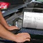 Gros plan d’un mécanicien utilisant les nouvelles méthodes de remplacement des composants du moteur et les schémas électriques