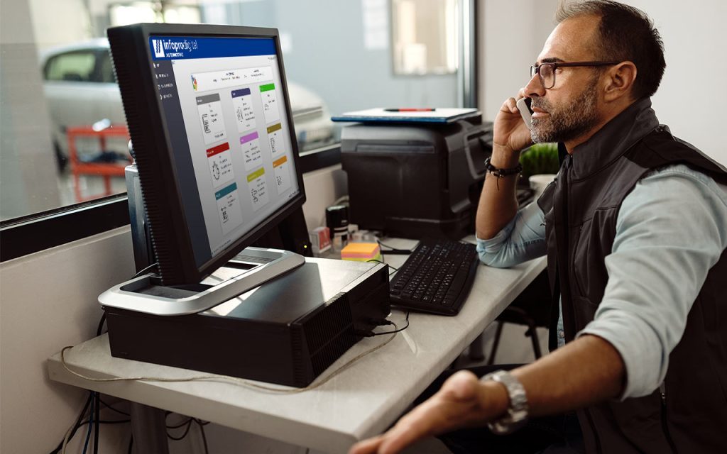car mechanic in the office using Workshop Management Software from Infopro Digital Automotive