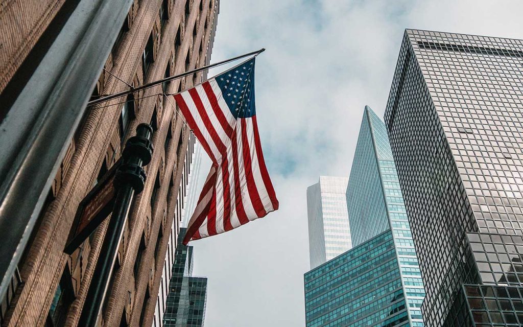 American flag flying between buildings to represent the usa market of infopro digital automotive