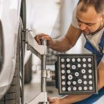 technicien automobile procédant au calibrage ADAS à l’aide d’un outil spécialisé dans un atelier moderne