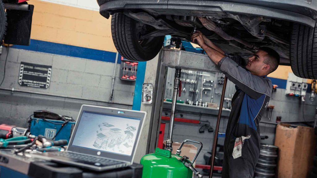 Mecánico reparando vehículo con la ayuda de I2I Catálogo de piezas de Infopro Digital Automotive