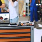 Ordinateur portable posé sur une servante et qui permet d'identifier le véhicule en atelier avant de commencer les réparations