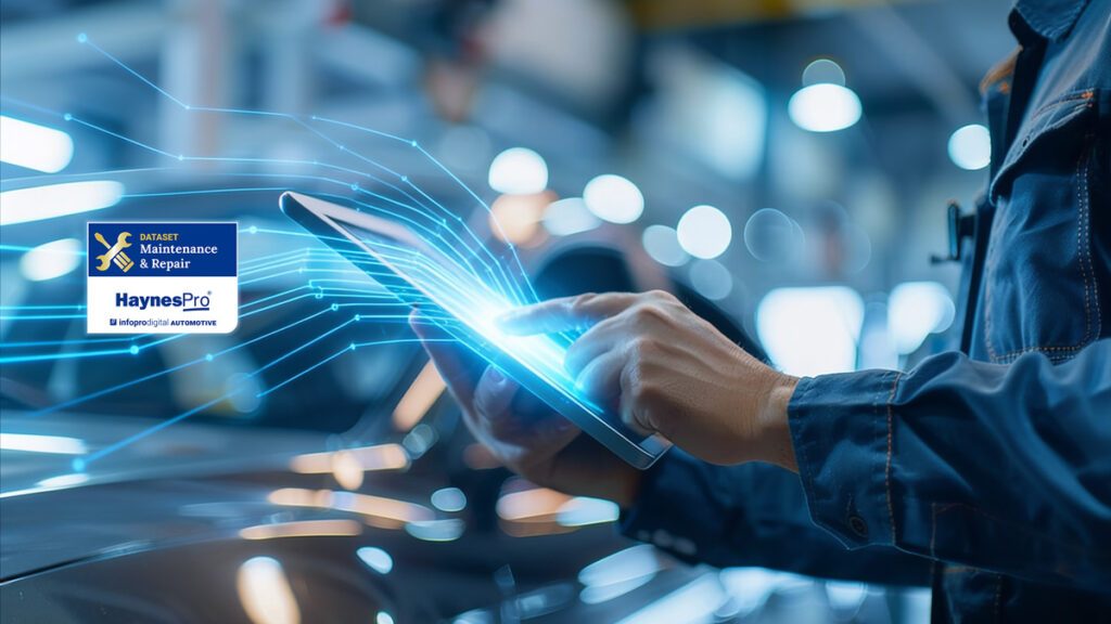 Automotive technician using a tablet in a workshop with HaynesPro Maintenance and Repair dataset integration overlay