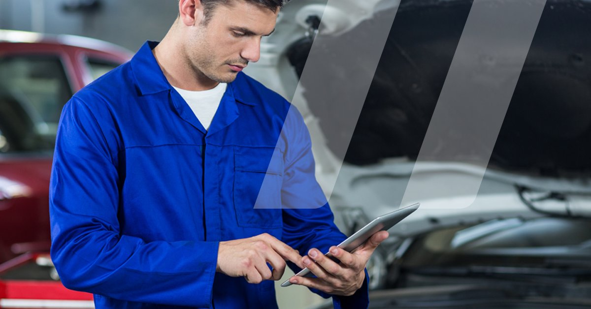 Mécanicien regardant sa tablette lors de son intervention afin de profiter des outils Infopro Digital Automotive disponibles sur smartphone et tablette