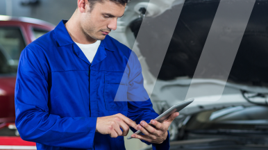Mécanicien regardant sa tablette lors de son intervention afin de profiter des outils Infopro Digital Automotive disponibles sur smartphone et tablette