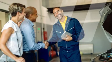 Car mechanic smiling while talking to customers