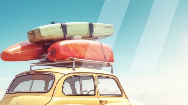 Voiture jaune rentrant de vacances avec des kayaks et des valises sur le toit, illustrant le thème du check-up de la voiture après les vacances d'été.