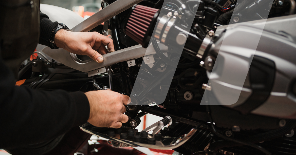 Meccanico che ripara il motore di una moto in officina specializzata per le due ruote