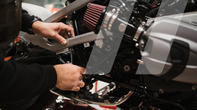 Meccanico che ripara il motore di una moto in officina specializzata per le due ruote