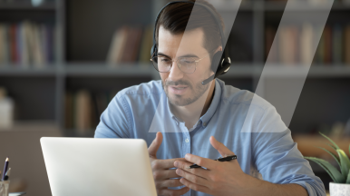 Formateur en plein formation à distance certifiée Qualiopi devant son ordinateur et avec un casque-micro