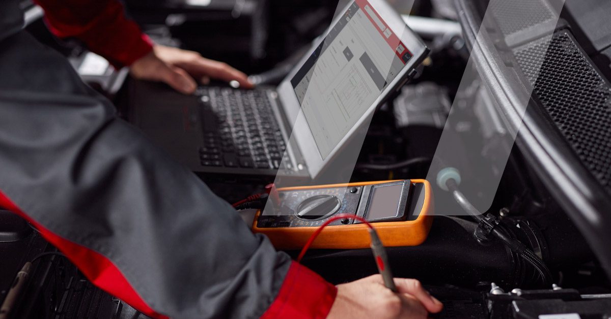 Meccanico che effettua una diagnosi utilizzando la banca dati Infopro Digital Automotive sullo schermo del suo computer
