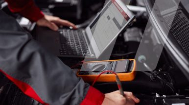 Mecánico realizando un diagnóstico con una herramienta de Infopro Digital Automotive en la pantalla de su ordenador.