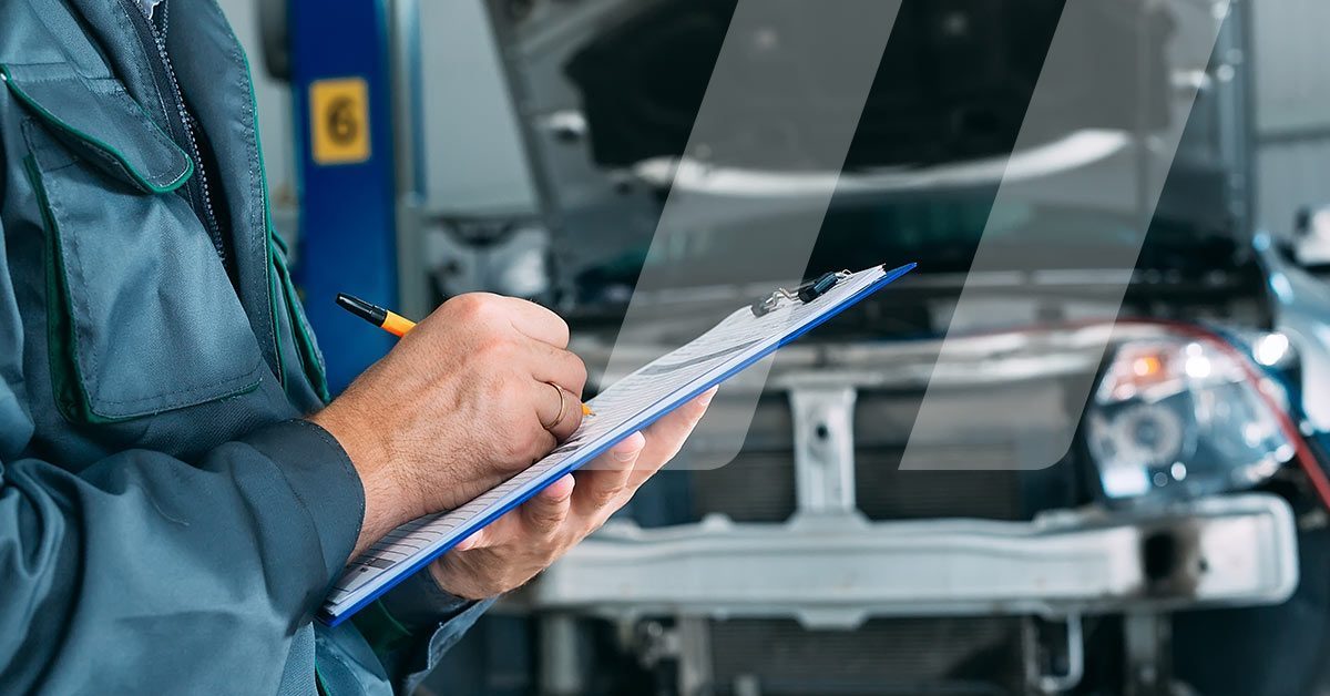 Meccanico auto che copila una scheda di accettazione per officine al fine di accogliete al meglio i clienti