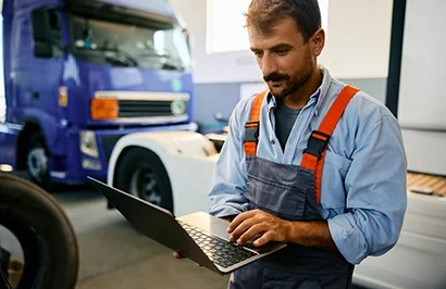 Mécanicien de poids lourds qui commande des pièces à l'aide du catalogue en ligne Atelio Parts Truck.