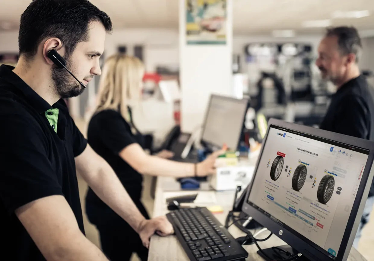 Homme au comptoir consultant les stocks et les modèles de pneus disponibles à la vente en e-commerce via Ino'Shop