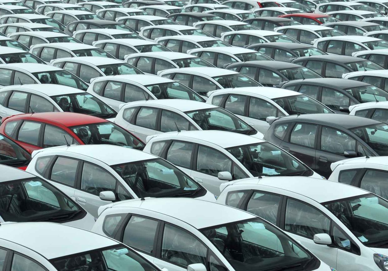 Image of many white and some red cars representing the car parc in circulation