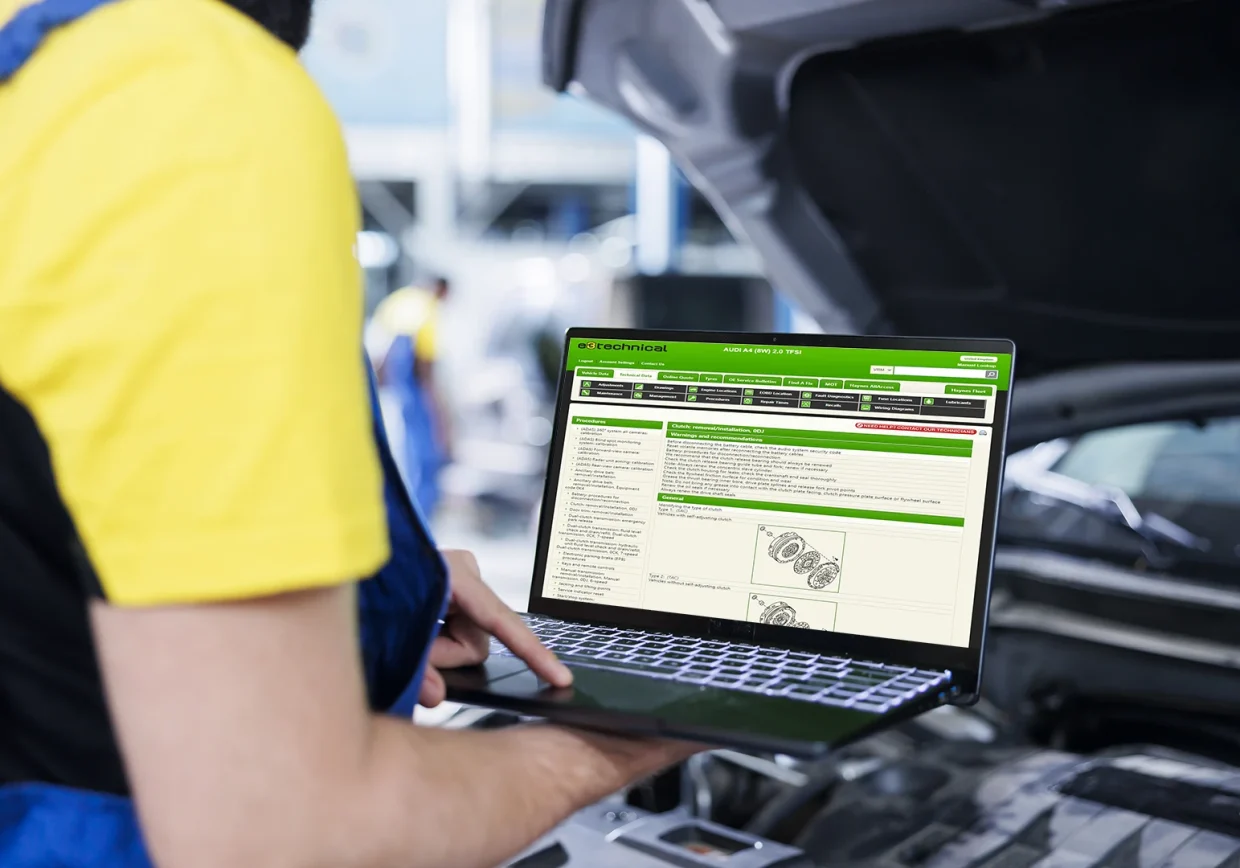 car mechanic who uses a PC with e3technical data to repair a car