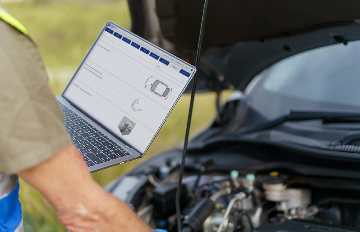 Un tecnico di carro attrezzi consulta i dati tecnici di Roadside per sbloccare un'auto durante un soccorso stradale