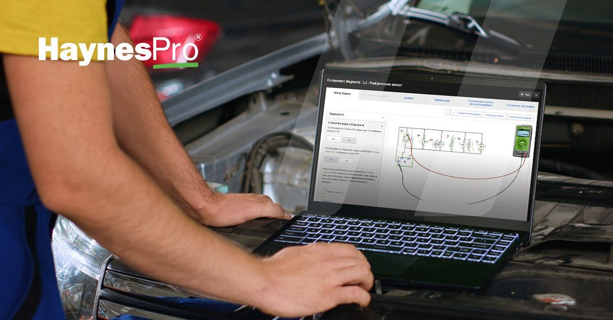 Close-up of a mechanic using HaynesPro’s new engine component replacement procedures and wiring diagrams