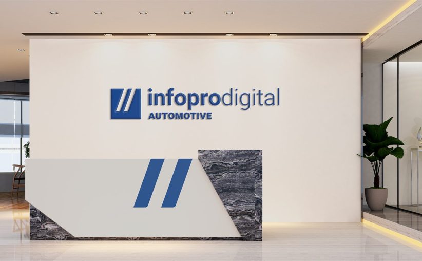 Modern reception area of Infopro Digital Automotive USA offices with company logo on the wall and a stylish front desk.