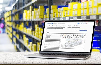 Représentation d'un ordinateur avec OnePro Shop, plateforme e-commerce B2B pour distributeurs, à l'intérieur d'un entrepôt de pièces détachées.